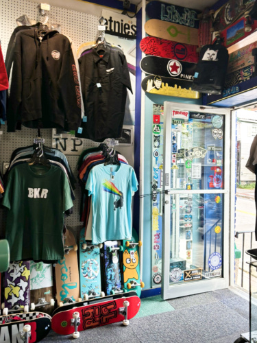 View of the t-shirts and skateboards displayed inside the store