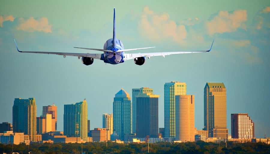 Skyline with warm sunset light with an airplane landing at Tampa International Airport