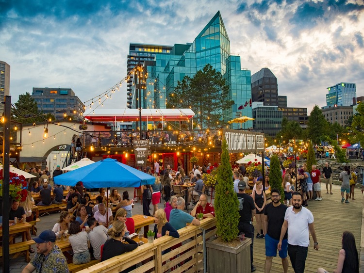 View of many people in outdoor cafe with modern buildings background