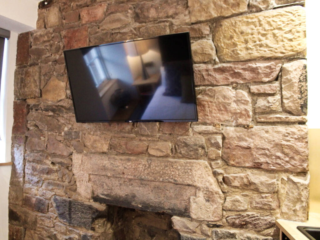 The TV hanged against the stone wall