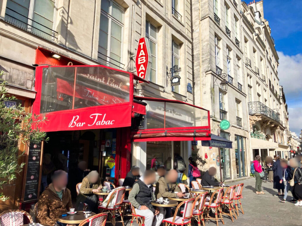 People enjoying at the Tabac's terrace in Paris on a sunny day