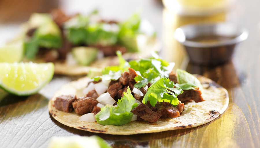 View of an authentic tacos with beef and vegetables on it