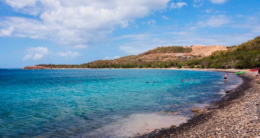 View of people swimming in the blue water of Tamarindo Beach