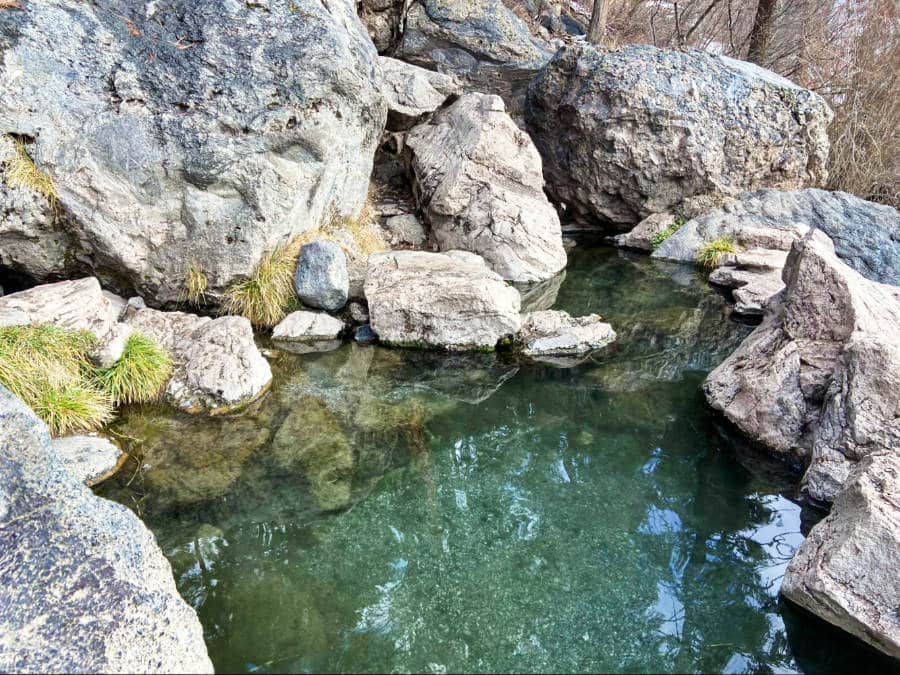 View of the hot spring surrounded by big rocks