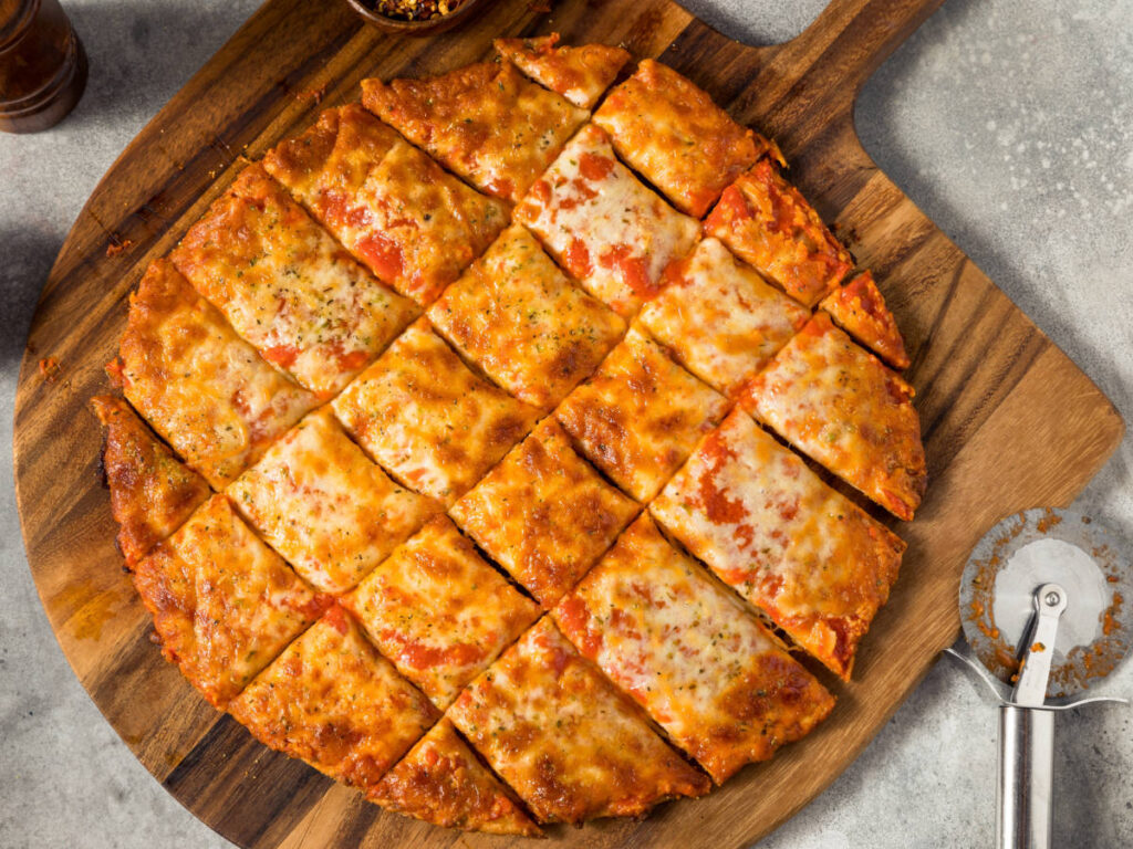 A whole tavern-style pizza cut in small square