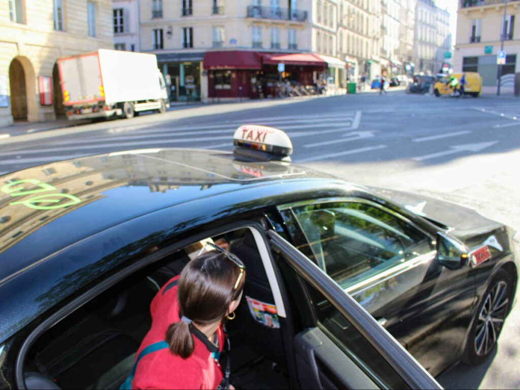 Writer Betty stepping into a taxi in Paris