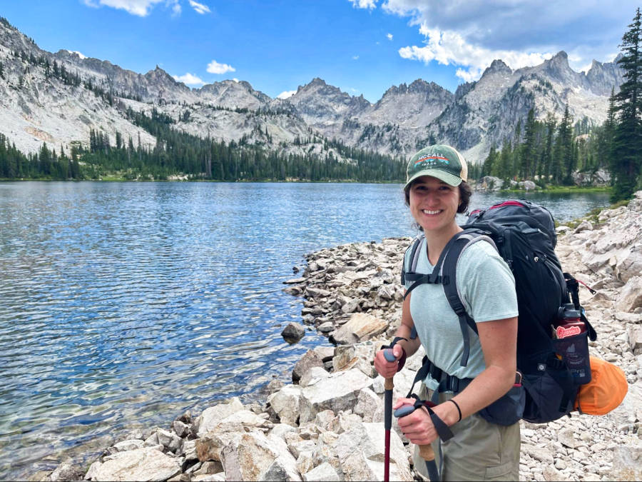 The author, Taylor, posing near the lake during her backpacking trip in the Sawtooths