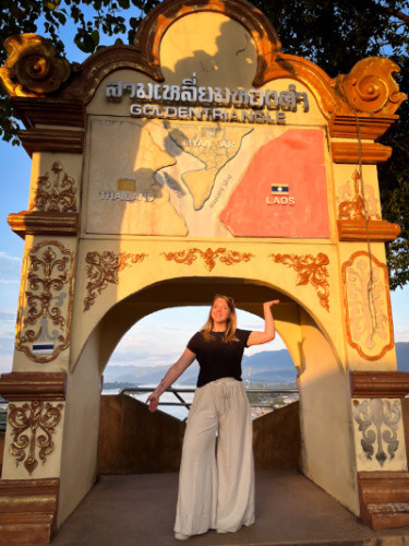 The author Taylor Herperger, posing for a photo under the archway at the Golden Triangle