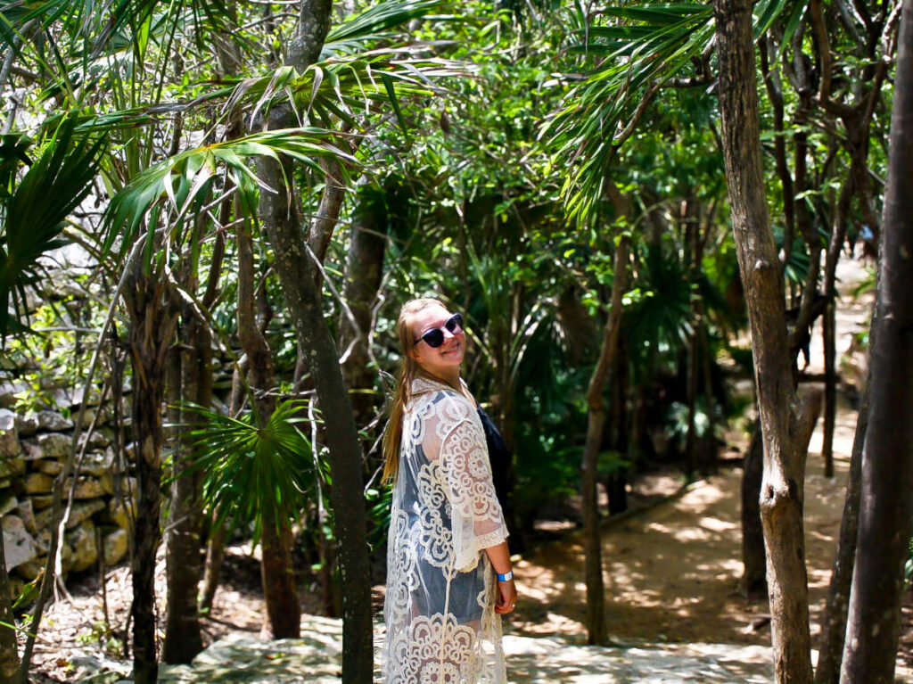 The author Taylor Herperger, smiling for a photo while exploring the Tulum Ruins