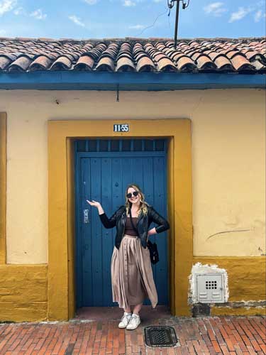 Taylor Herperger posing for a photo in front of a door in Bogota, Colombia