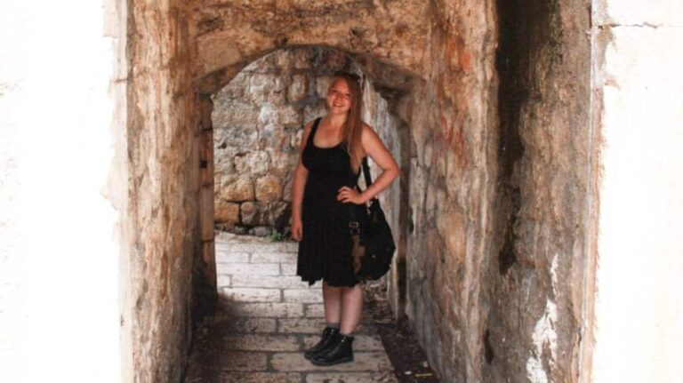 The author Taylor Herperger, posing at the brick walled street in Dubrovnik’s Old Town