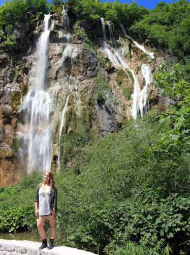 The author Taylor Herperger posing for a photo in front of the waterfalls in Plitvice Lakes National Park