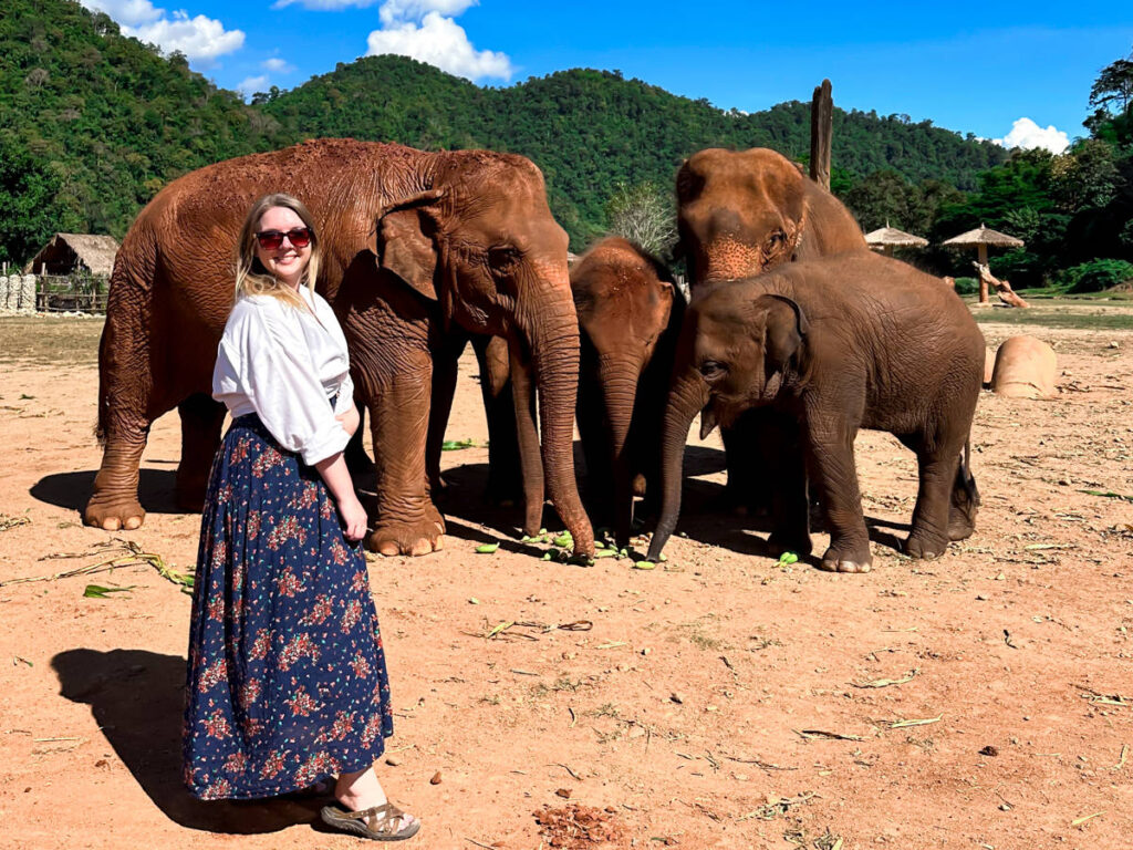 The author Taylor Herperger, posing for a photo with the elephants in Chiang Mai