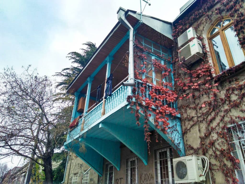 View of the blue balcony with vines around in Old Town Tbilisi