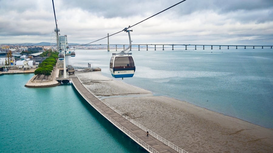 A cable car going down on the scenic view of the city and river in Lisbon