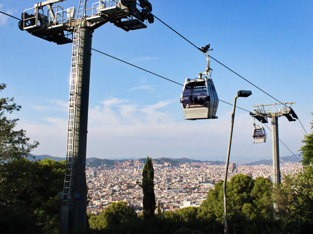 View of the Telefèric de Montjuïc cable cars over Barcelona with a clear blue sky in the background