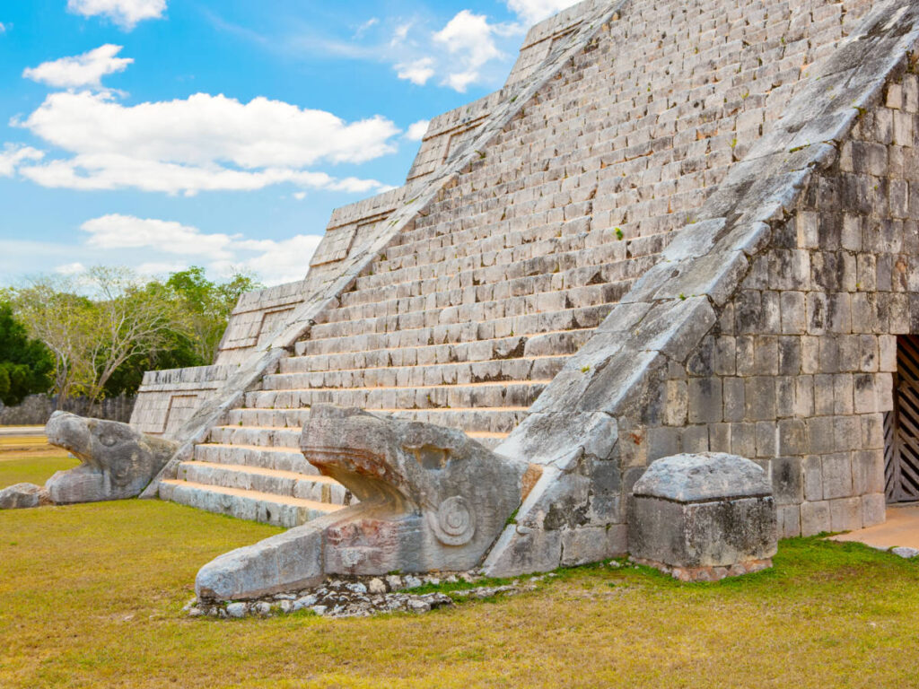 Snake head sculptures at the base of El Castillo or Temple of Kukulcan in Chichen Itza