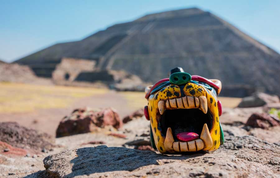 A colorful Teotihuacan crafts whistle and the Pyramid of the Sun on the background