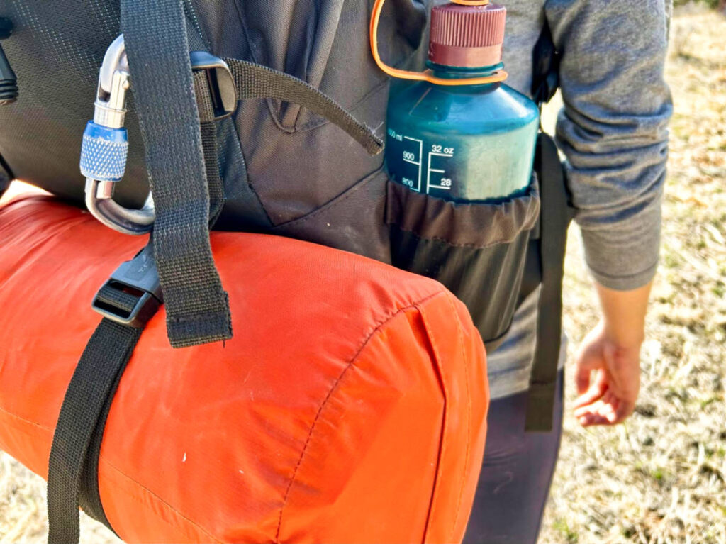 View of the attached gear and drink bottle on the exterior pocket