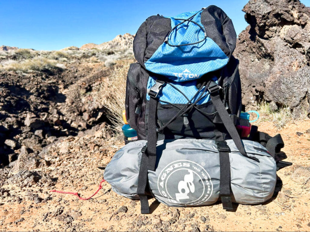 The Teton Sports Scout Backpack with other gear in a rocky landscape