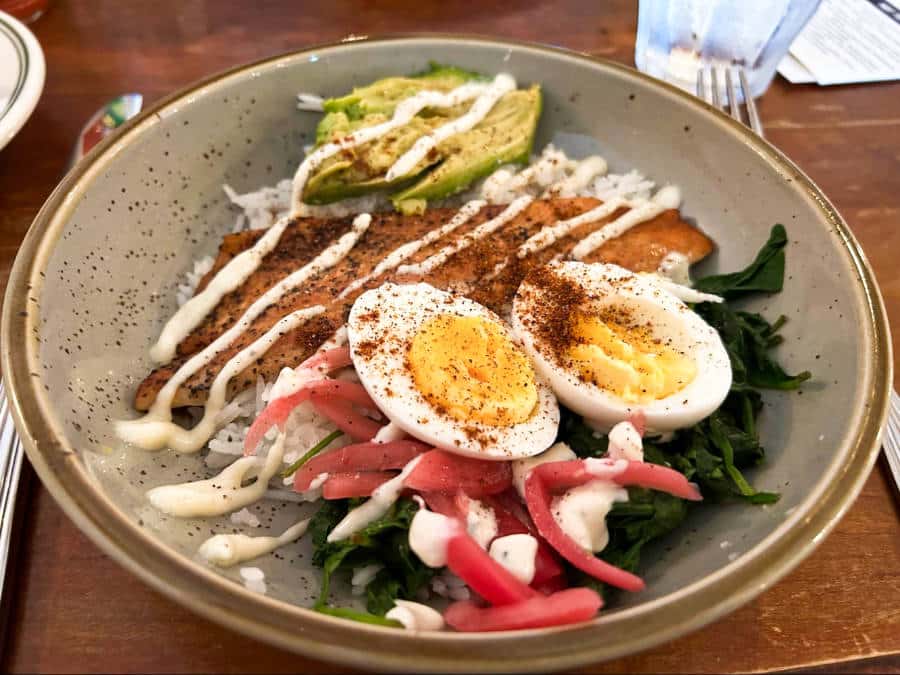 The Arthur's Brunch bowl with vegetables and sliced boiled eggs drizzled with white sauce