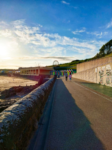 View of the couple walking along the walkway in Barry Island
