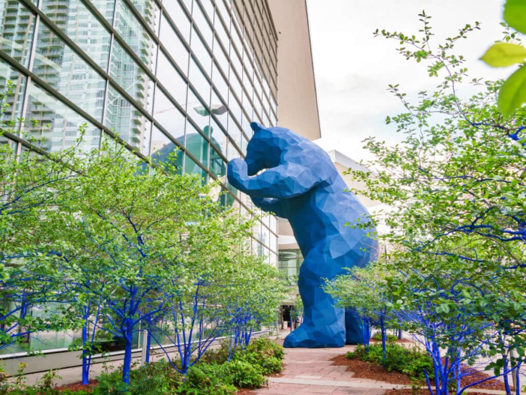 A big blue bear statue peeking outside the Colorado Convention Center