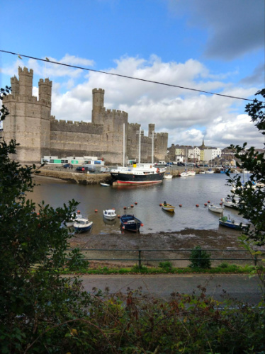 View of Caernarfon Castle with boats docked in the waters