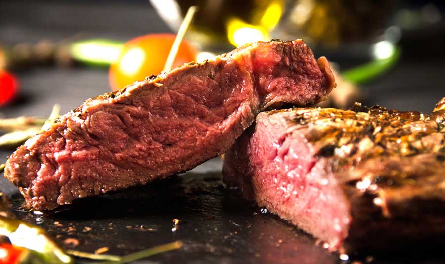 Close up view of a rare steak on a wooden board from The Capital Grille