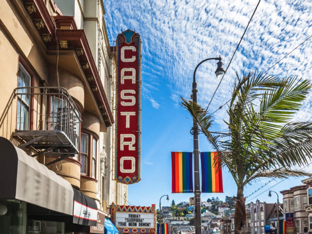 View of the signage at the Castro District with the LGBTQ+ flags in the background