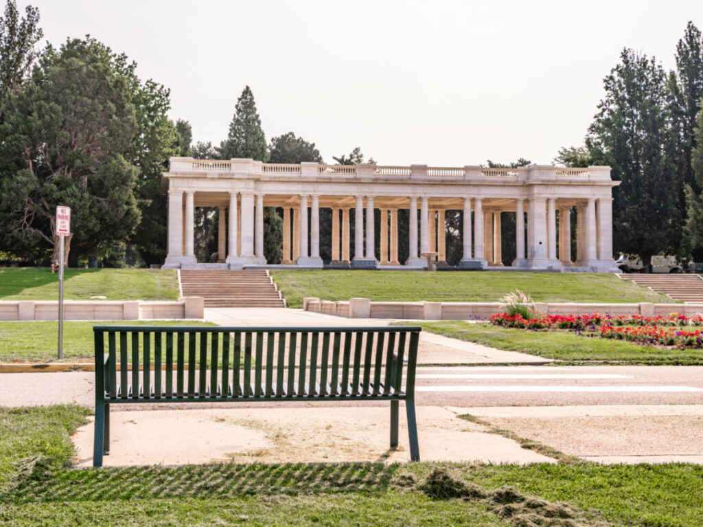 A bench in front of the Pavilion in Cheesman Park