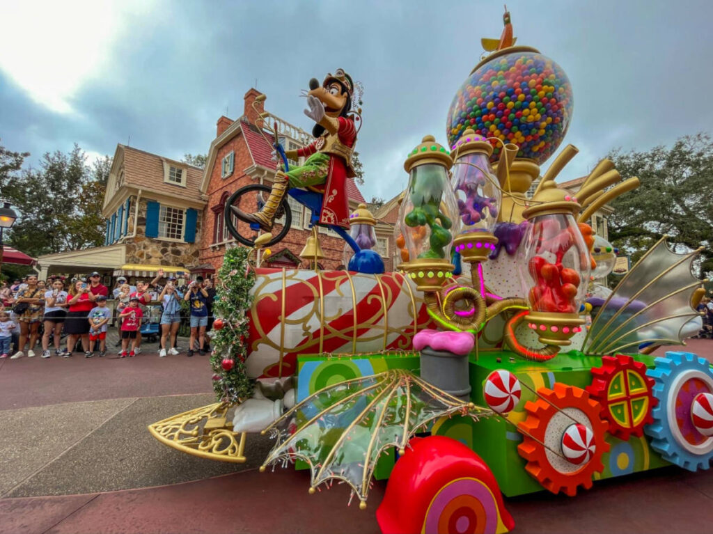 Goofy riding a candy themed ride at The Christmastime Parade