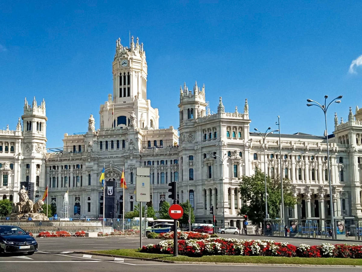 Panoramic view of the intricate exterior of The Cibeles Palace seen from across the street