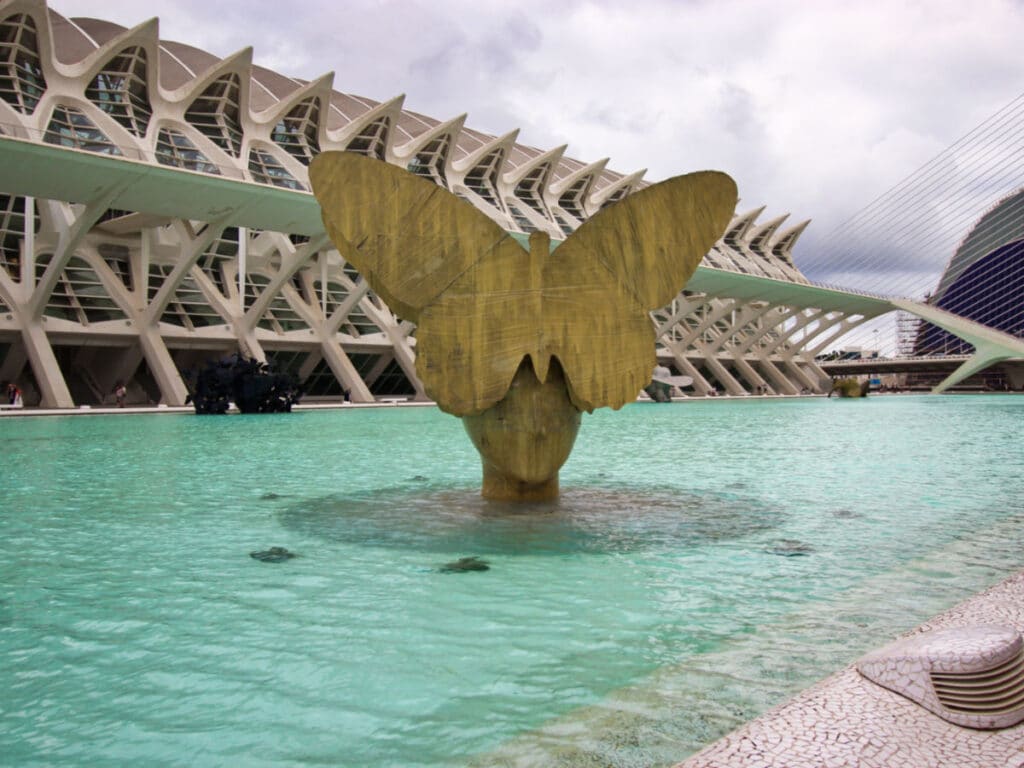 View of the unique architecture piece of a face with a huge butterfly on the head on the pool at The City of Arts and Sciences