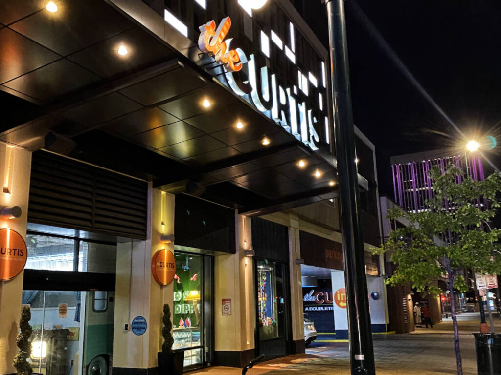 View of the entrance to The Curtis Denver hotel at night