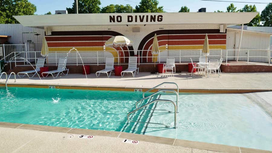 View of the lounge chairs under the shade near the pool in The Dive Motel