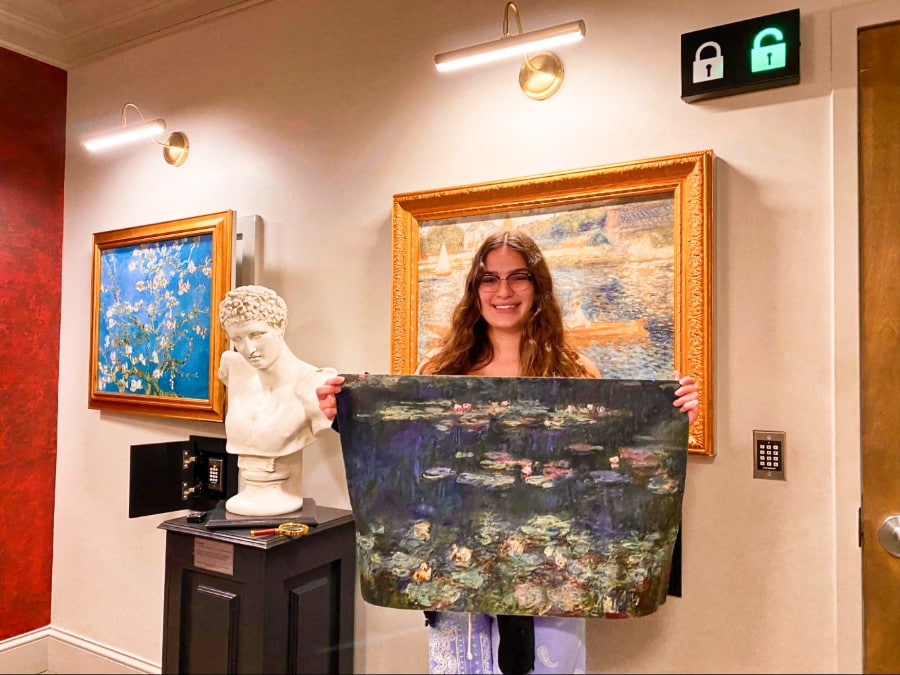 The author Isabelle Pavese holding an artwork inside The Heist escape room