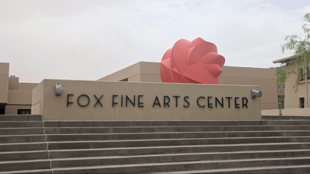 A large red sculpture behind the Fox Fine Arts Center sign at the University of Texas at El Paso