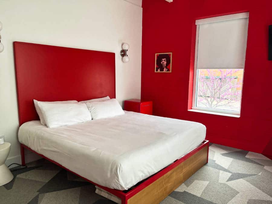 View inside the hotel room with red accent wall and headboard
