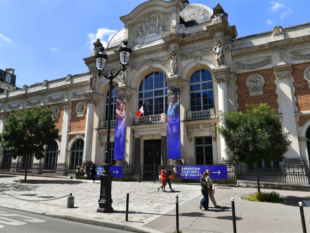 People walking past the Manufacture des Gobelins factory building in Paris