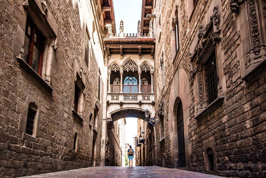 A male backpacker in the middle of a narrow street in the Gothic Quarter