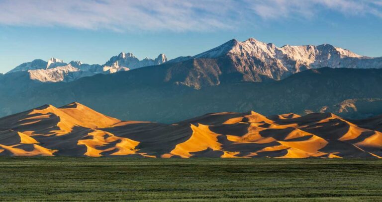 Scenic landscape of the Great Sand Dunes National Park featuring vast sandy hills and surrounding mountain ranges