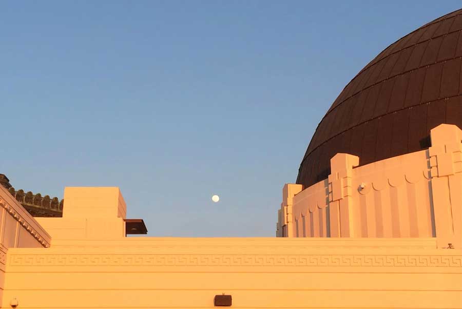 View of the moon rising over the Griffith Observatory