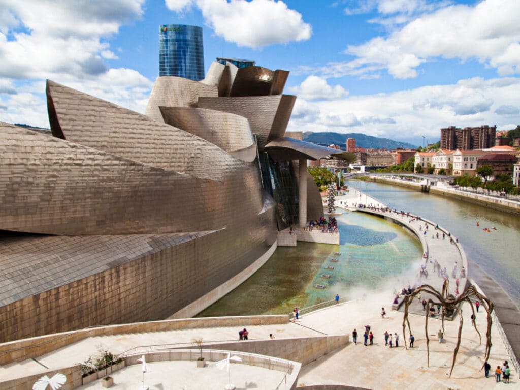 View of the people wandering around the cool and unique sculpture and exterior of The Guggenheim Museum Bilbao