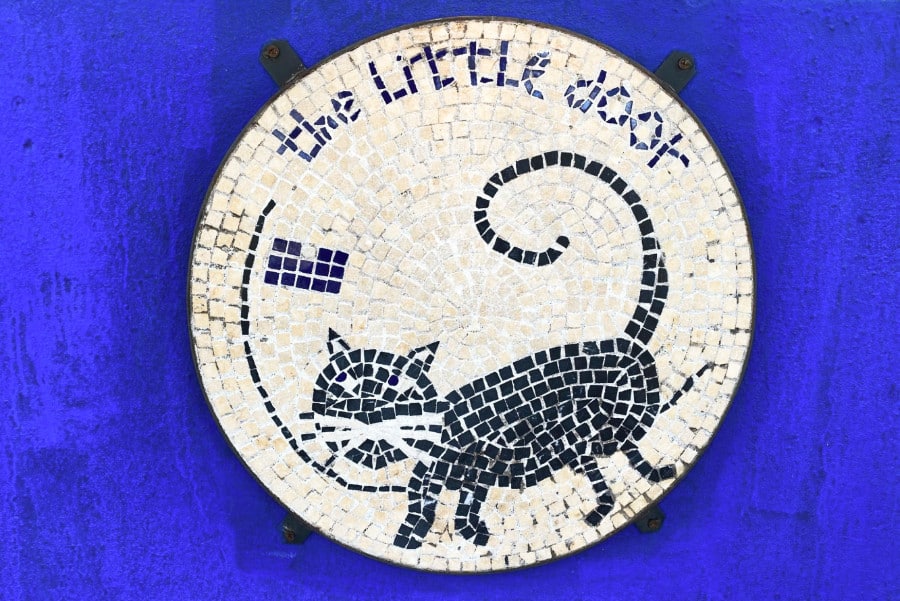 A mosaic signage with a cat of The Little Door