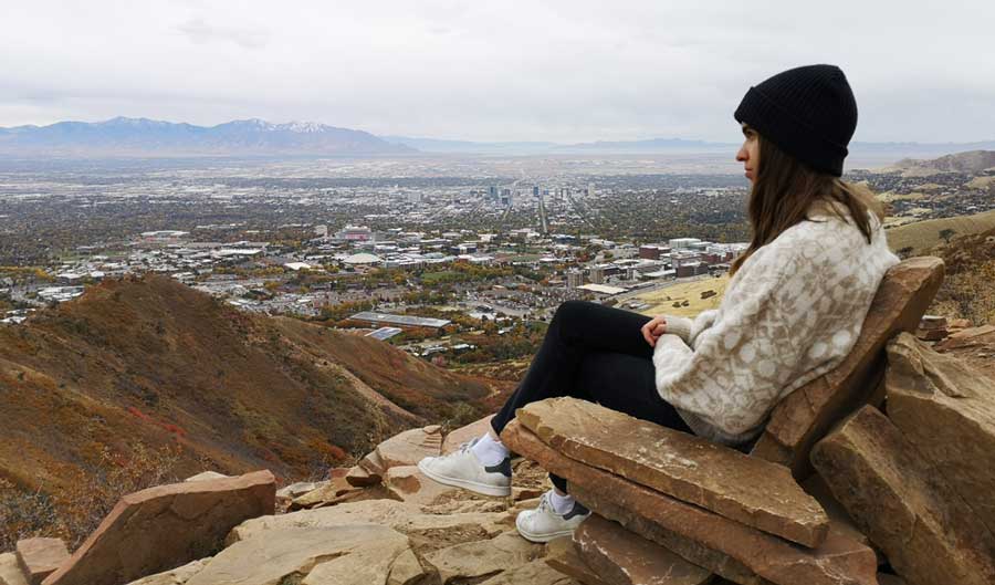 A woman sitting on a rock chair admiring the view in The Living Room