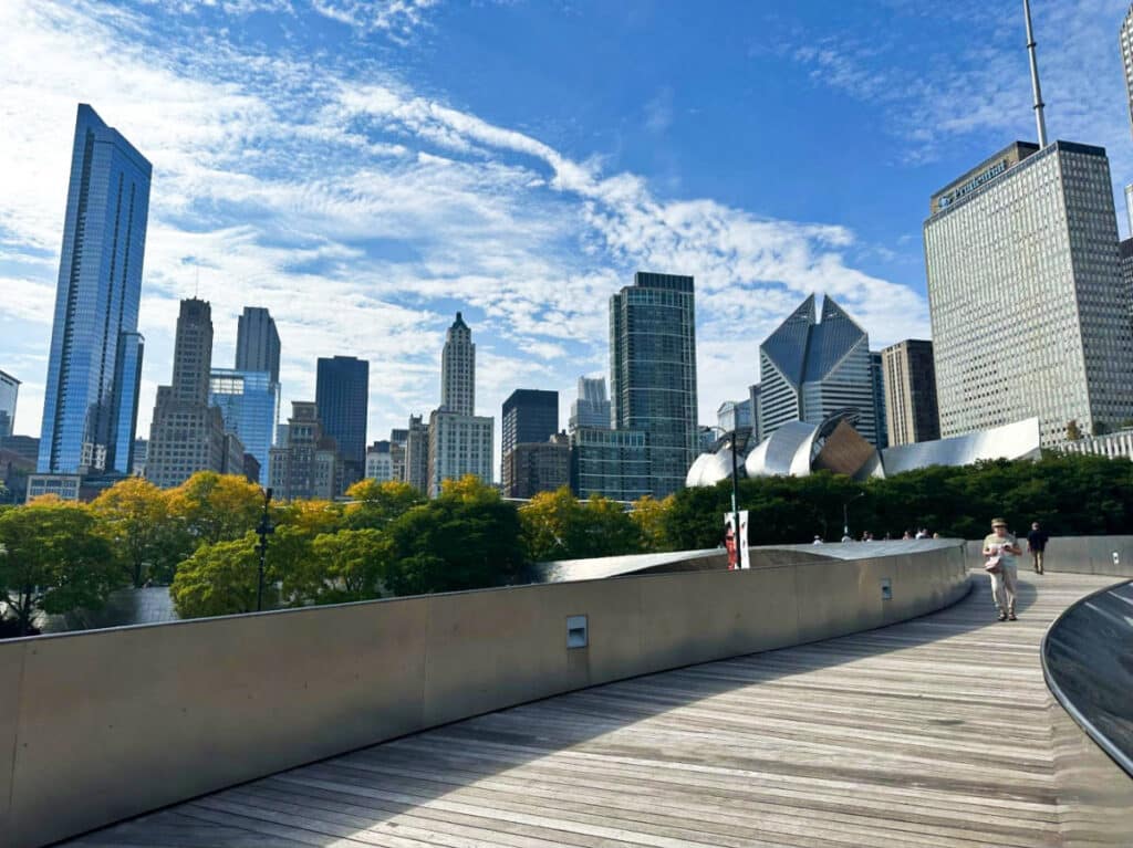View of the people wandering around at BP Pedestrian Bridge in Grant Park with the Loop skyline in the background