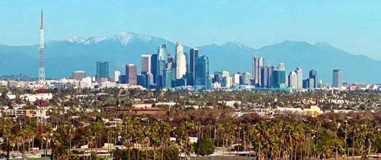 A panoramic view of the Los Angeles skyline against a backdrop of stunning mountains