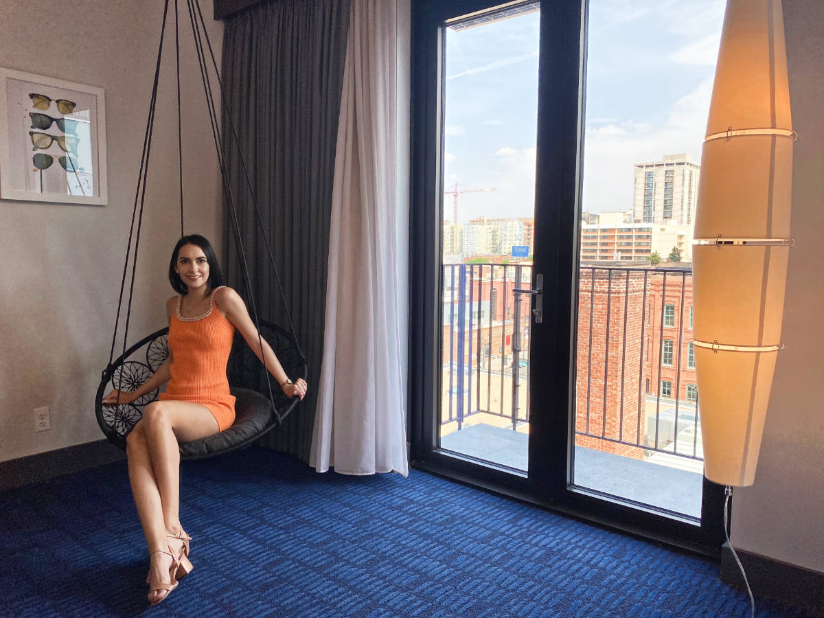 Clara Kesseler sitting inside their room with a balcony view in The Maven Hotel Denver 