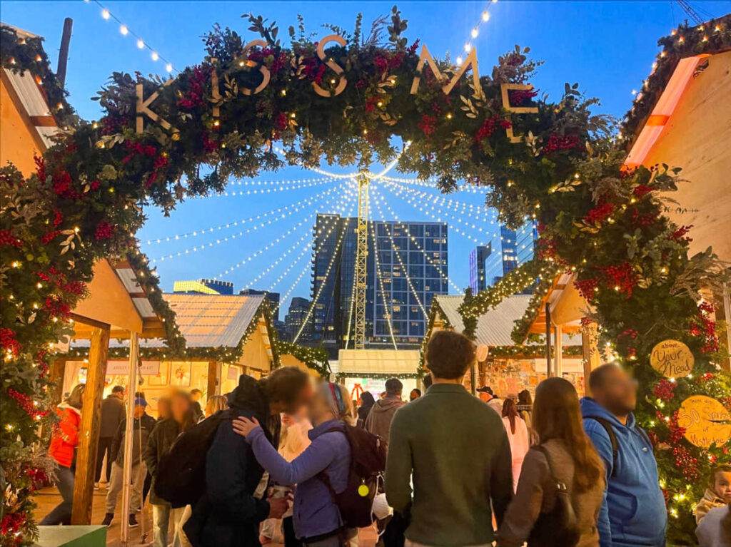 A couple kissing under The Mistletoe Arch